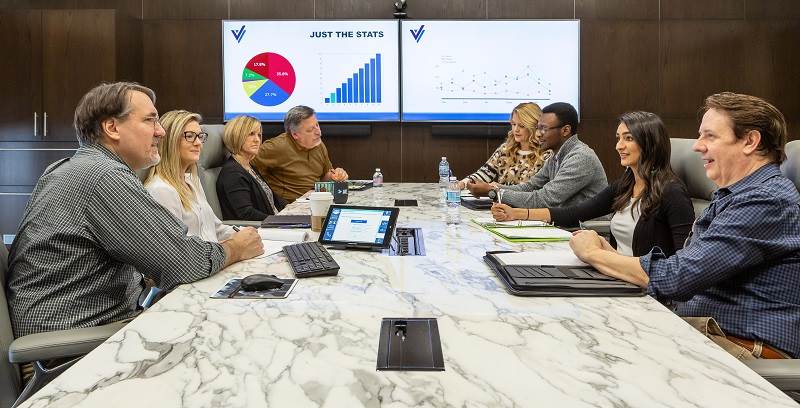 people sitting in a conference room viewing charts and graphs